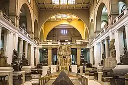 Interior courtyard view of the Egyptian Museum showing visitors and stone artifacts