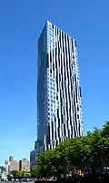 Toren, a high-rise clad in multiple of colors of glass in irregular patterns, viewed from street level