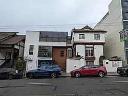 Three similarly sized buildings all with light paneling and dark wood trim