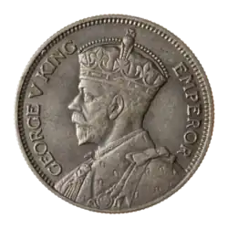 A crowned portrait of George V in royal dress, with the encircling text GEORGE V KING to the left, and EMPEROR to the right.