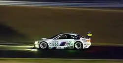 Side view of a white BMW M3 GT2 during night time driving conditions