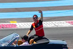 Leclerc sitting on the back of a black convertible before the 2022 French Grand Prix