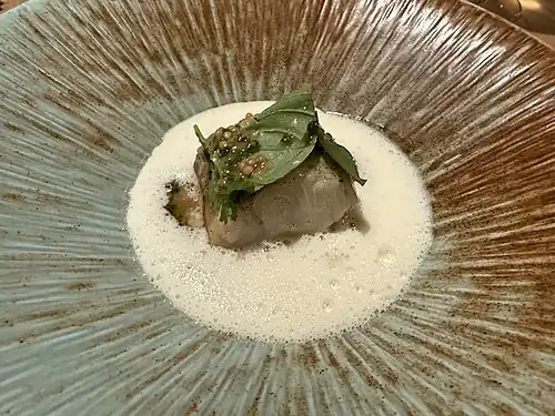 Fish in a frothy sauce poured at the table.