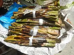 Tupig, made from ground glutinous rice, coconut strips, coconut milk, sugar, and wrapped in banana leaves
