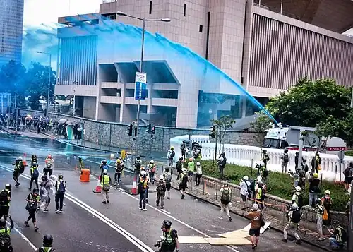 Police using blue-dye water canon to disperse and identify protesters
