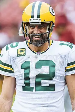 Aaron Rodgers smiling on the field in uniform