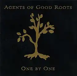 A gold foil tree debossed on a black background with foil spelling out the artist and album name