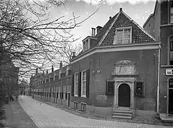 A black and white picture showing a row of houses, taken from the corner of the street