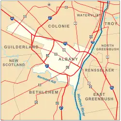 A map of Albany, highlighted in yellow on an orange background. The Hudson River is a blue meandering line down the middle. Interstate highways and major roads are represented by red lines