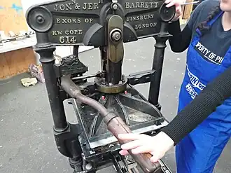 Pushing a lever to press the heavy platen against the tympan