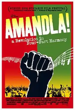 Against a background of red and green, a black fist grabs lines of musical notation from the air