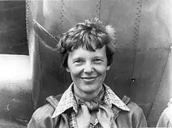 Amelia Earhart standing next to her aircraft