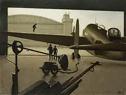 In an almost monochromatic composition, a World War Two twin-engined bomber is seen silhouetted against its open hangar door