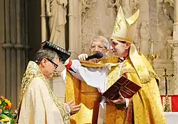 Archbishop Foley Beach presenting a Bible to Bishop Hobby at his consecration.