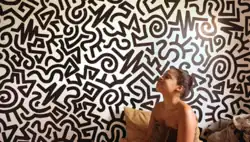 The poster depicts the writer, co-director, and star Taylor Garron in a towel looking straight ahead. She's in front of a wall with bold shaped print.