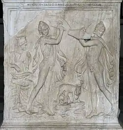 Infant Zeus is suckled, and two men hold shields