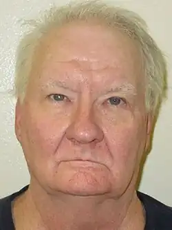 Mugshot of Schreiber, against a white wall