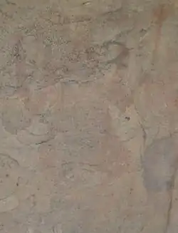 An eroded painting in the caves showing a man dancing and holding a trident-like staff