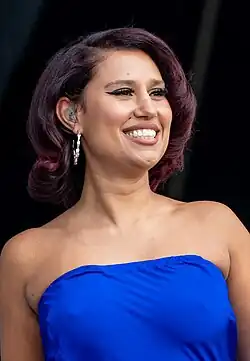 Raye smiling on the right