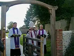 The Bishop of Horsham dedicating the tapsel gate in 2004, with the Rector and the bishop's domestic chaplain.