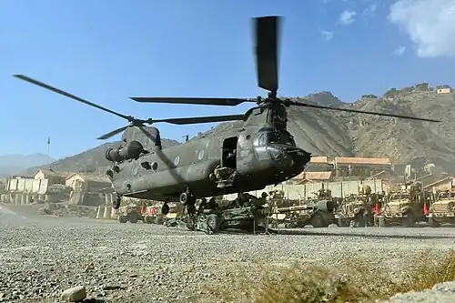 A CH-47 Chinook helicopter hooks up an M777 for sling loading