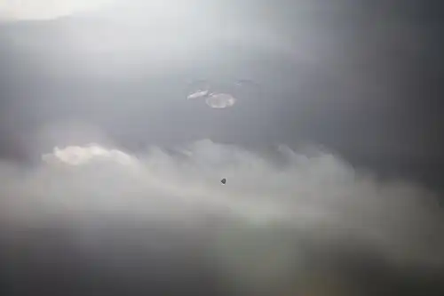 Dragon descending under parachute