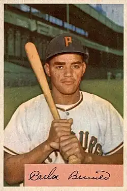 A man in a white baseball jersey and black cap