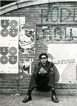 Carlos Mesa sits in front of a wall