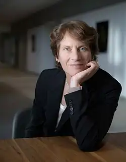 Headshot of Carolyn Bertozzi, a woman with short brown hair wearing a dark blazer