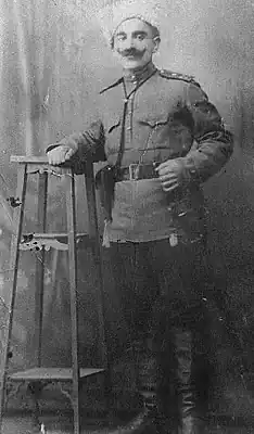 Pontian man in old military uniform posing with a gun.