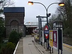 Railway station platform with a garden on one side and railway tracks on the other