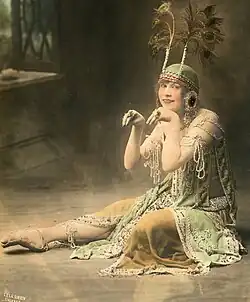Photograph of Schade sitting in elaborate vaudeville atire, with a feather headdress