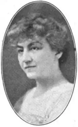A white woman with hair in an updo, wearing a dress with a square neckline, in an oval frame