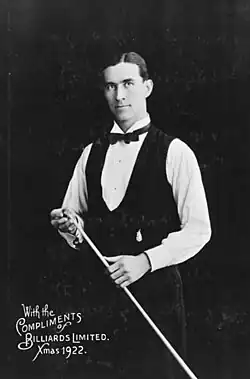 A man wearing a waistcoat, holding a billaird cue