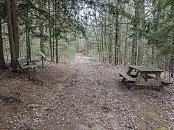 One of the trails with a bench, informational sign, and picnic table.
