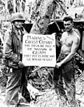 Marine Corps Privates First Class William A. McCoy and Ralph L. Plunkett holding a sign thanking the Coast Guard after the Battle of Guam in 1944[68]