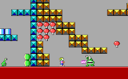 Side view of Commander Keen facing a Martian Garg enemy, surrounded by a structure composed of square blocks.