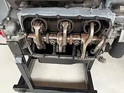 The picture shows the engine with the side panel removed. You can see the bottom of the three horizontally opposed pistons, connected to the unique rocker arms, which in turn provide power to the single internal crankshaft.