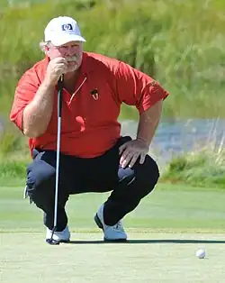 Stadler crouching on a golf course