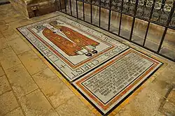 Mosaic memorial on cathedral floor showing bishop in robes and mitre