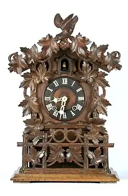 Carved spring-driven, mantel clock with bone hands, Gordian Hettich Sohn, Furtwangen, c. 1870 (Deutsches Uhrenmuseum)