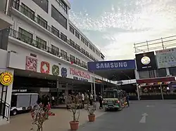 A white building consisting of ground floor shops with apartments/hotel rooms above
