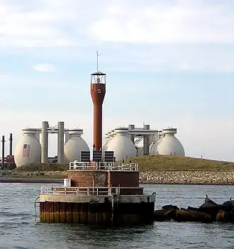 Deer Island Light in 2009, with Deer Island Waste Water Treatment Plant digesters in the background.