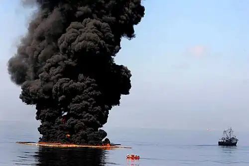 A controlled burn of oil creating a smoke plume