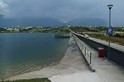 The Dam of the Lake of Farkë with the village of Farkë in the background