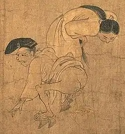 A man suffering from diarrhea squatting with a woman watching his back.