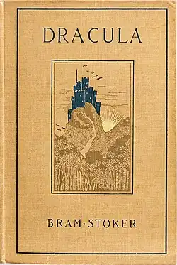 Book cover of 1899 edition. It has the name and title of the novel on a yellow-orange cover, depicting Dracula's castle upon a hill