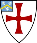 Shield of Durham University: Argent, a cross paty quadrate gules; on a canton azure a chevron or between three lions rampant argent.
