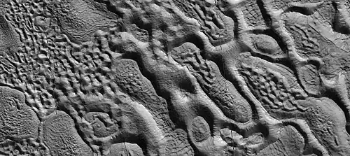 Close view of upper plains unit showing hollows--where ice left the ground. Picture is about 1 Km across. This is part of an image named HiRISE picture of the day for October 21, 2024.