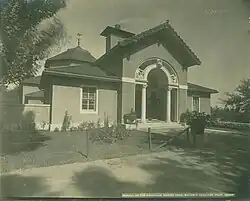 A black and white photo of an archway leading into a building with sculptures of exotic animals.